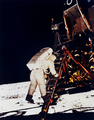 Buzz Aldrin in Space Suit climbs down the Eagle's ladder to the surface. of the moon